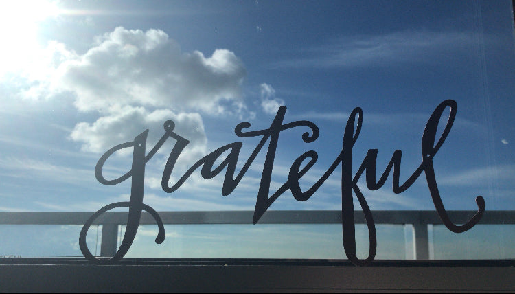 word 'grateful' with a beach background