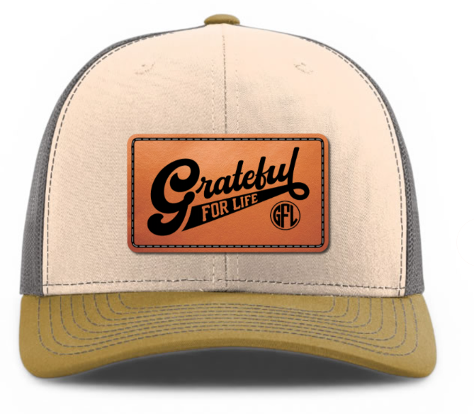 Beige and gray cap with a leather patch that says 'Grateful for Life' on a white background